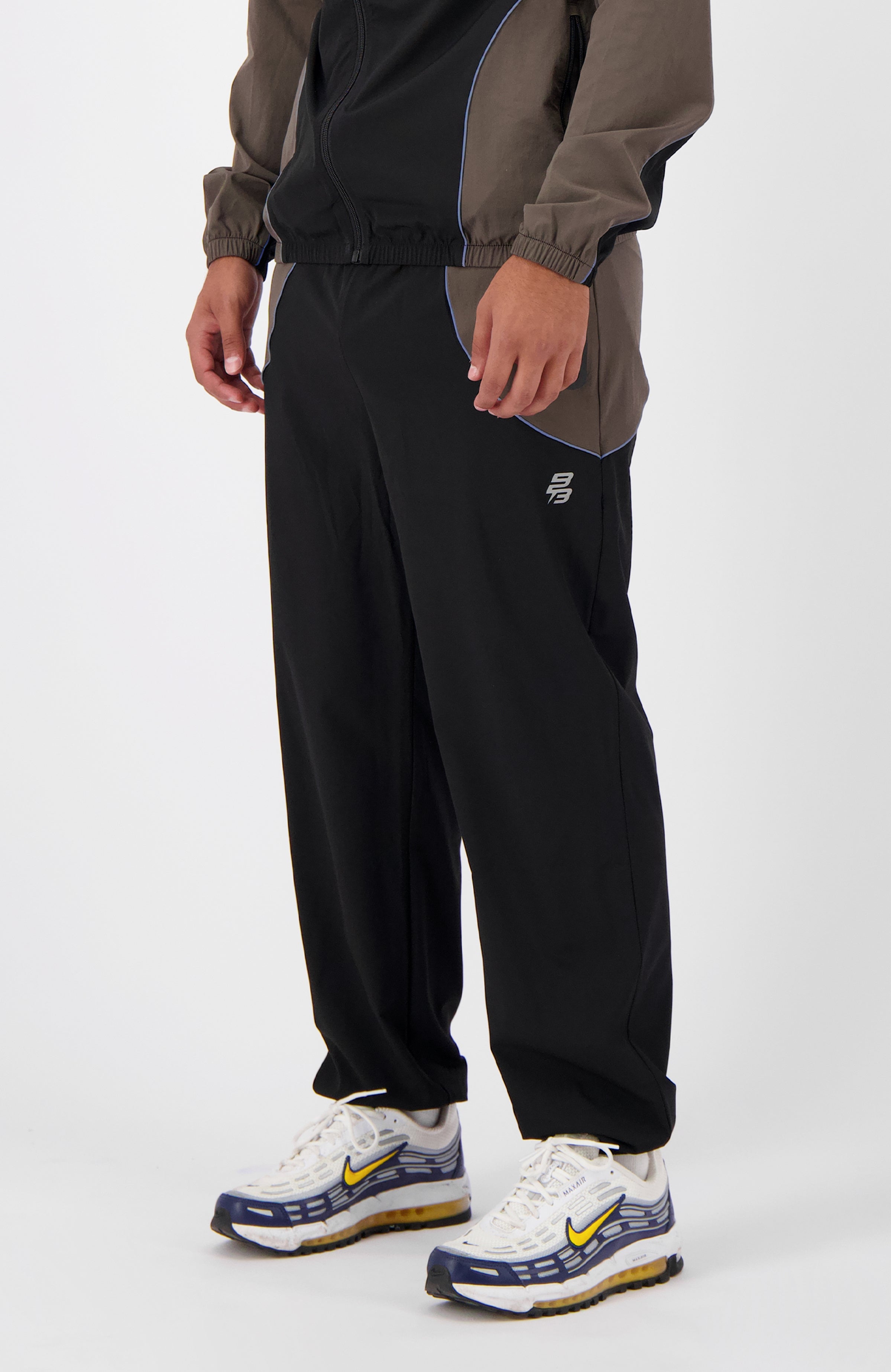 //blackbananas.com/cdn/shop/files/rflct-trackpants-1.124.4.42-000000-men-bottom-06_{width}x.jpg?v=1736864833